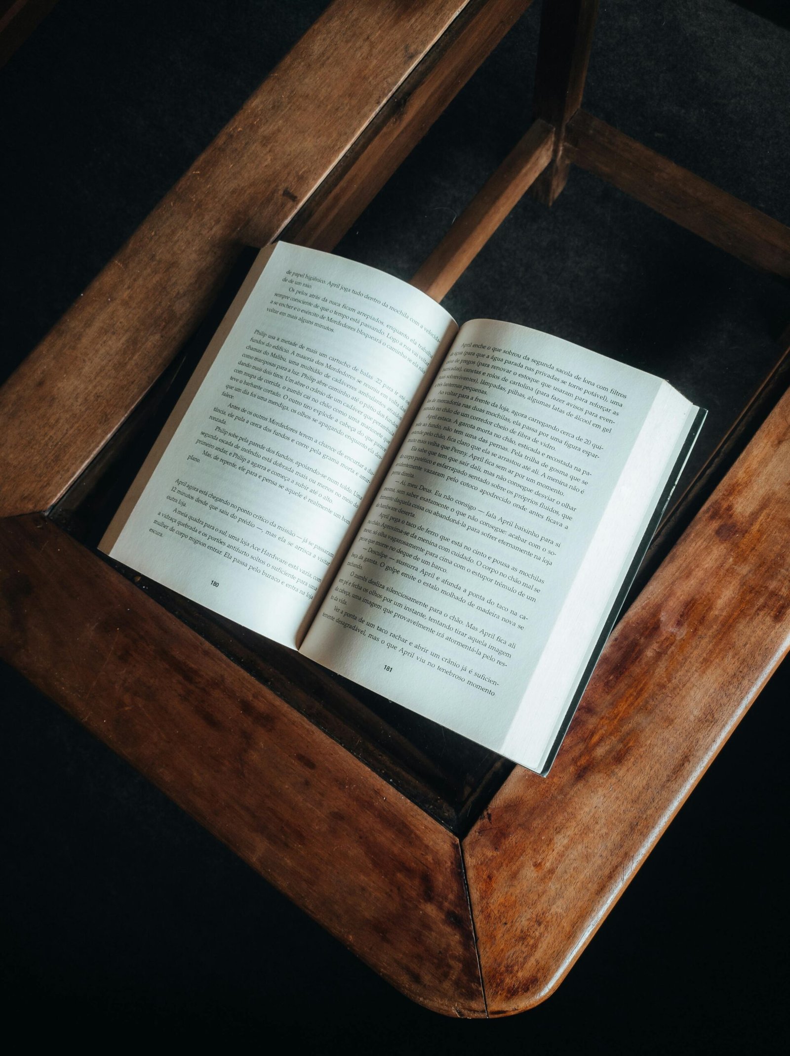 An open book resting on a wooden coffee table, viewed from above.